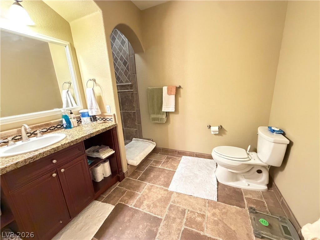 12 Via Visione, #204, Henderson, NV 89011 An arched doorway leads to the walk-in shower in this tile-floored bathroom.