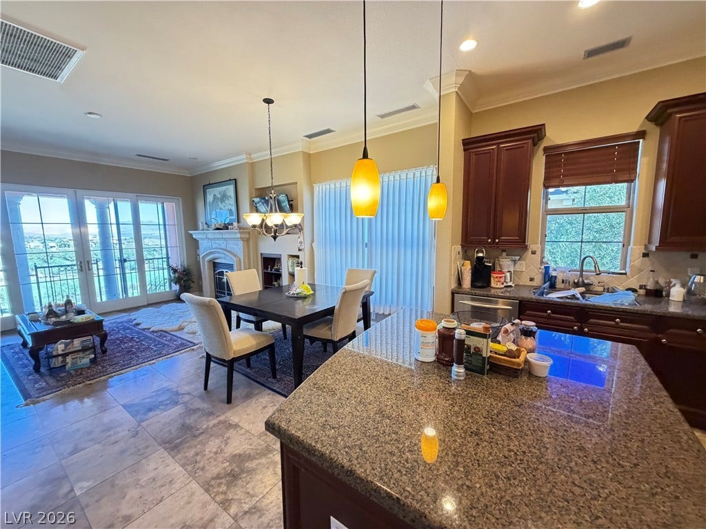 12 Via Visione, #204, Henderson, NV 89011 Granite countertops and rich cabinetry highlight an airy kitchen flowing into the dining area.