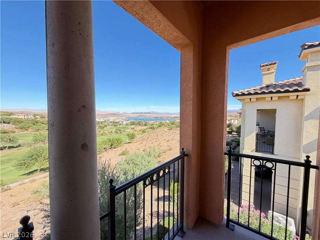 12 Via Visione, #204, Henderson, NV 89011 Panoramic mountain and water views unfold from a covered balcony with elegant stone pillars.