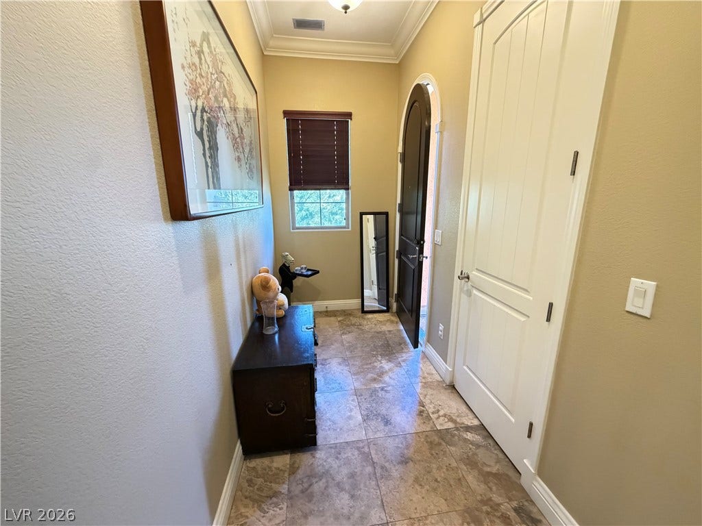 12 Via Visione, #204, Henderson, NV 89011 Stone tile flooring and crown molding define this welcoming entryway.