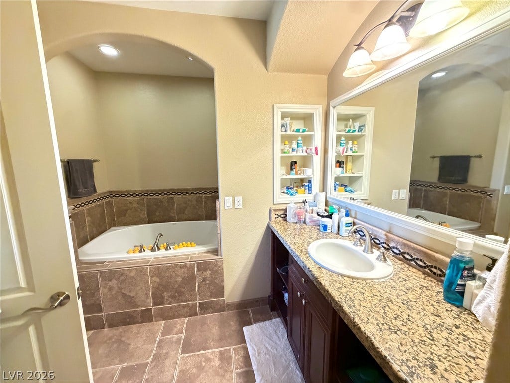12 Via Visione, #204, Henderson, NV 89011 An arched alcove frames the deep soaking tub alongside a granite-topped vanity.