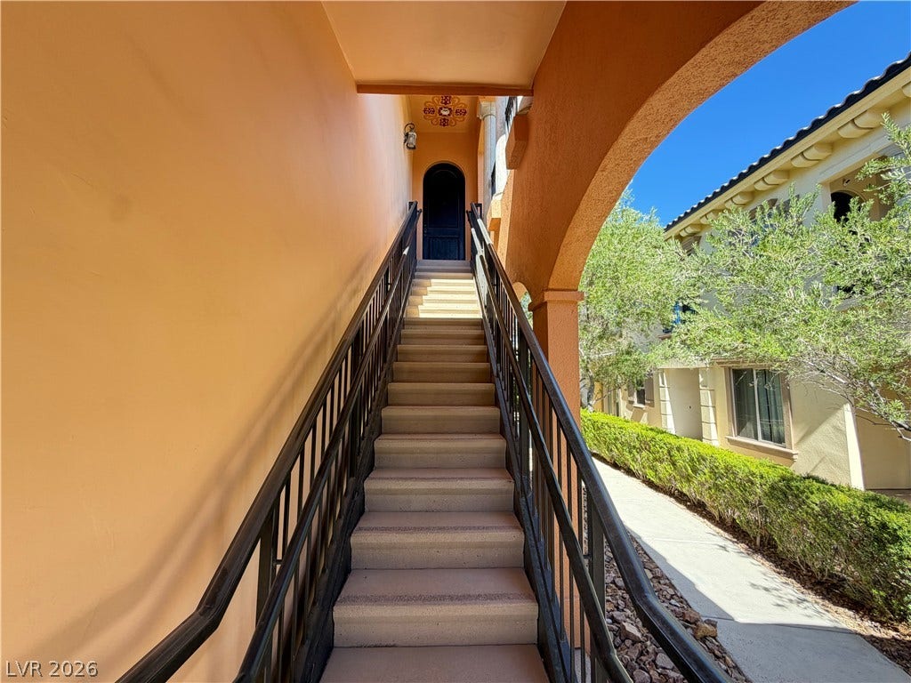 12 Via Visione, #204, Henderson, NV 89011 An arched outdoor staircase lined with dark handrails leads to an elevated private entry.