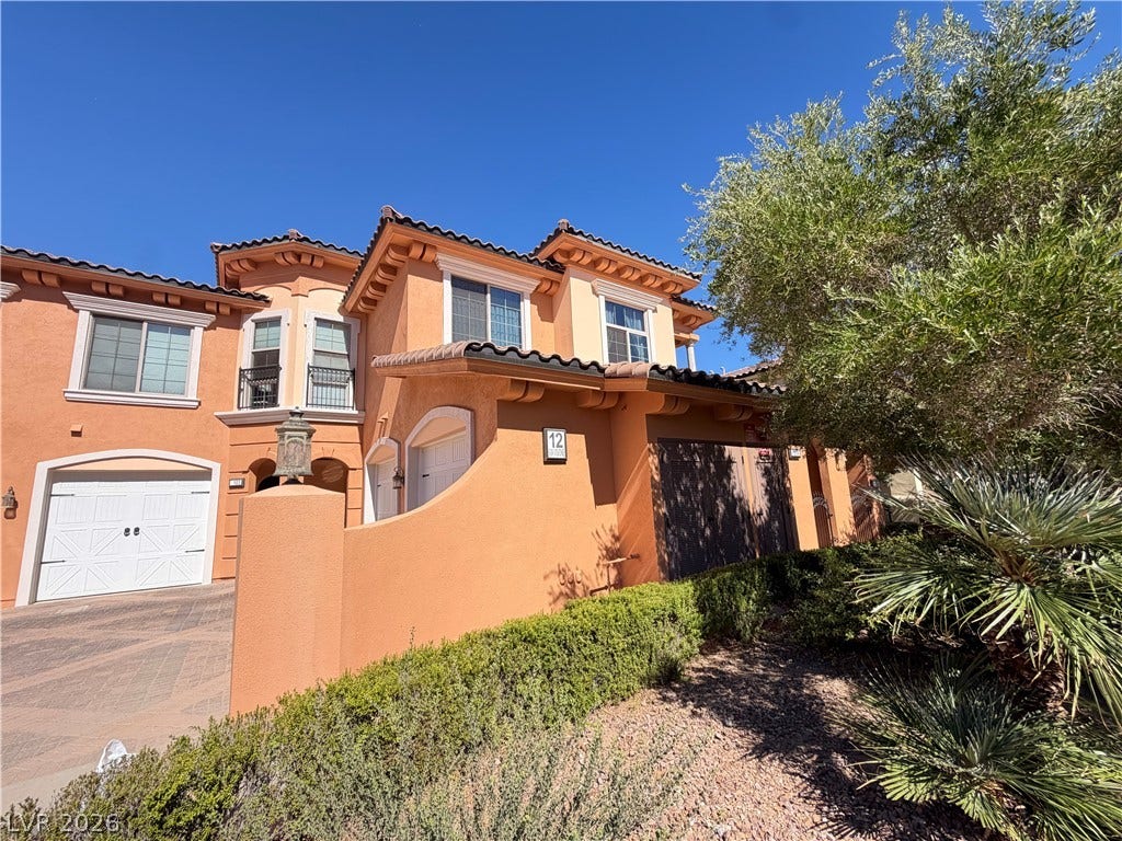 12 Via Visione, #204, Henderson, NV 89011 Mediterranean architectural details and mature desert landscaping define the exterior of this multi-level townhouse.