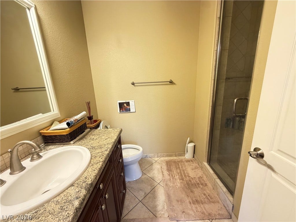 12 Via Visione, #204, Henderson, NV 89011 A glass-enclosed walk-in shower complements the granite vanity in this functional bathroom.