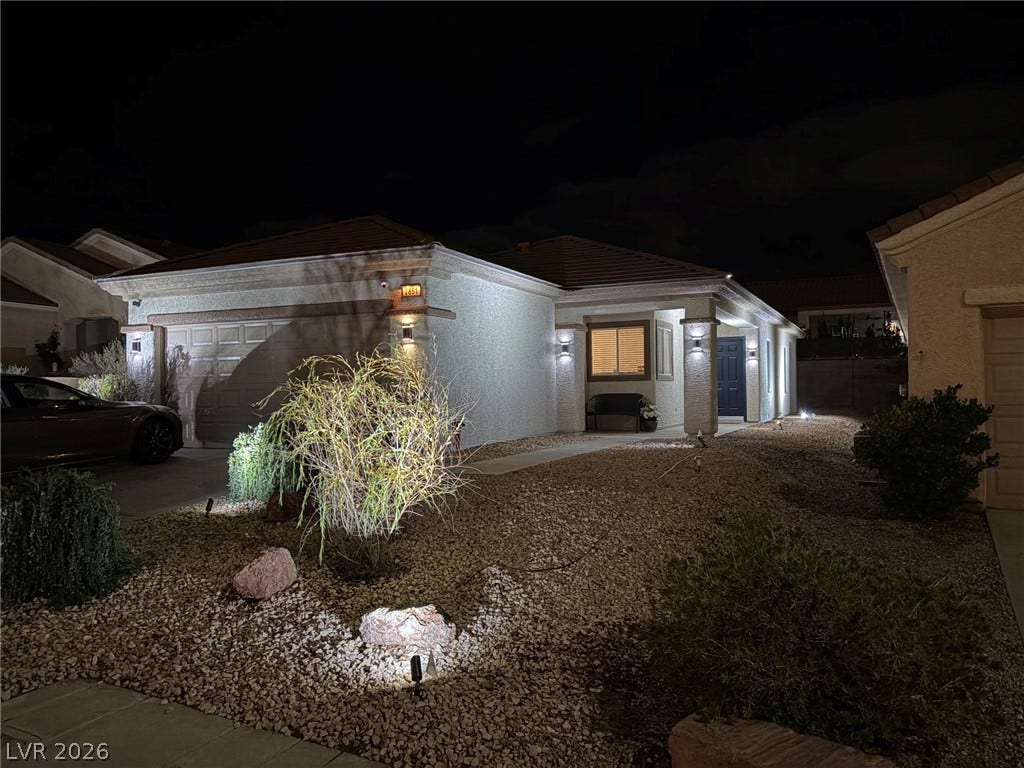 2851 Sapphire Desert Drive, Henderson, NV 89052 Thoughtfully placed landscape lighting highlights the neat front yard and textured stucco exterior at night.