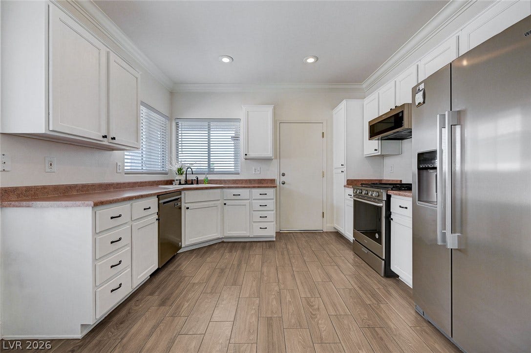 2851 Sapphire Desert Drive, Henderson, NV 89052 Gleaming wood-look flooring and crisp crown molding frame this spacious kitchen featuring abundant cabinetry.