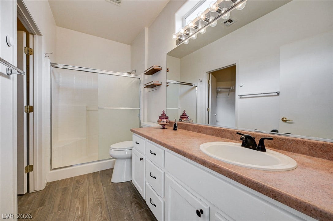 2851 Sapphire Desert Drive, Henderson, NV 89052 Warm wood-look flooring and a generous vanity with integrated sink complete this practical bathroom.