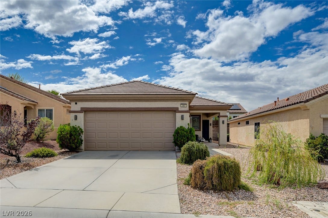 2851 Sapphire Desert Drive, Henderson, NV 89052 Desert landscaping and a concrete driveway lead to this classic stucco exterior with tile roof.