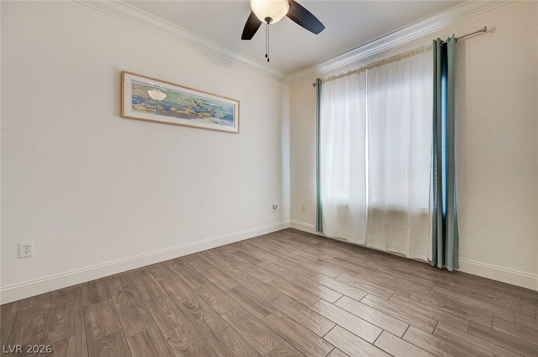 2851 Sapphire Desert Drive, Henderson, NV 89052 Rich wood-look tile flooring and elegant crown molding elevate this versatile secondary bedroom.
