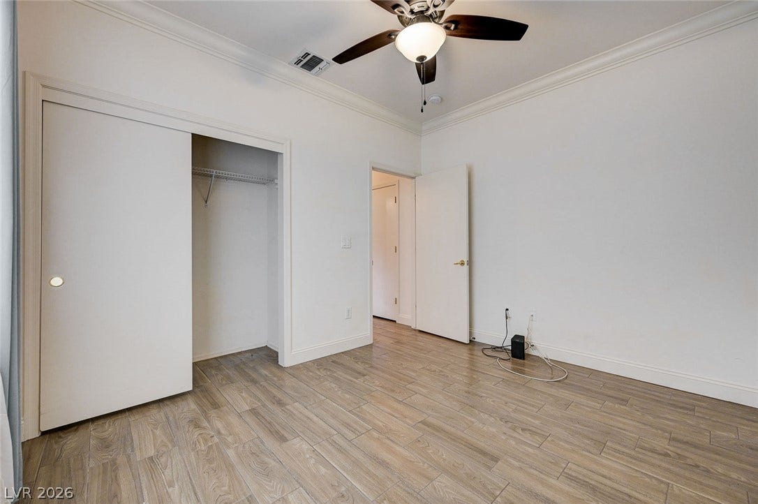 2851 Sapphire Desert Drive, Henderson, NV 89052 Elegant crown molding complements the sleek wood-look plank flooring in this versatile bedroom.