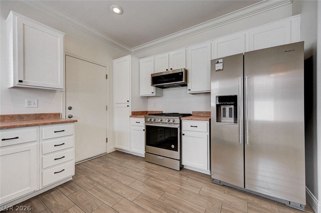 2851 Sapphire Desert Drive, Henderson, NV 89052 Crown molding and wood-look flooring enhance this kitchen space with classic charm.