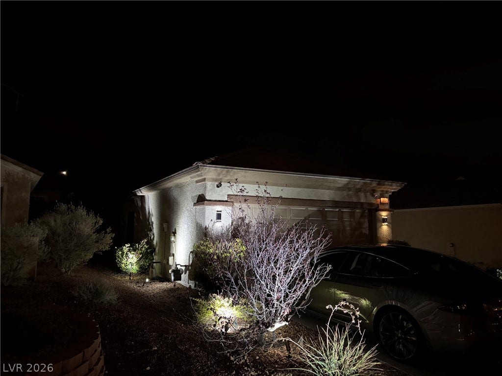 2851 Sapphire Desert Drive, Henderson, NV 89052 Exterior uplighting accentuates the professional landscaping and stucco facade after dark.