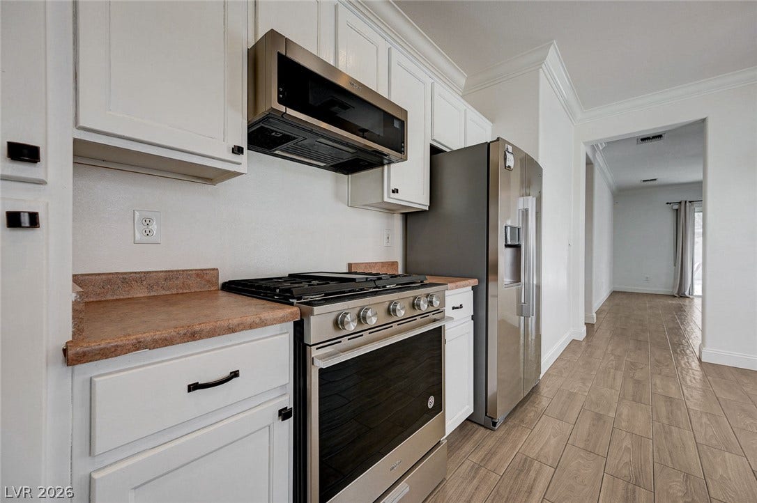 2851 Sapphire Desert Drive, Henderson, NV 89052 Gleaming stainless steel appliances complement classic white cabinetry and durable wood-look tile flooring.