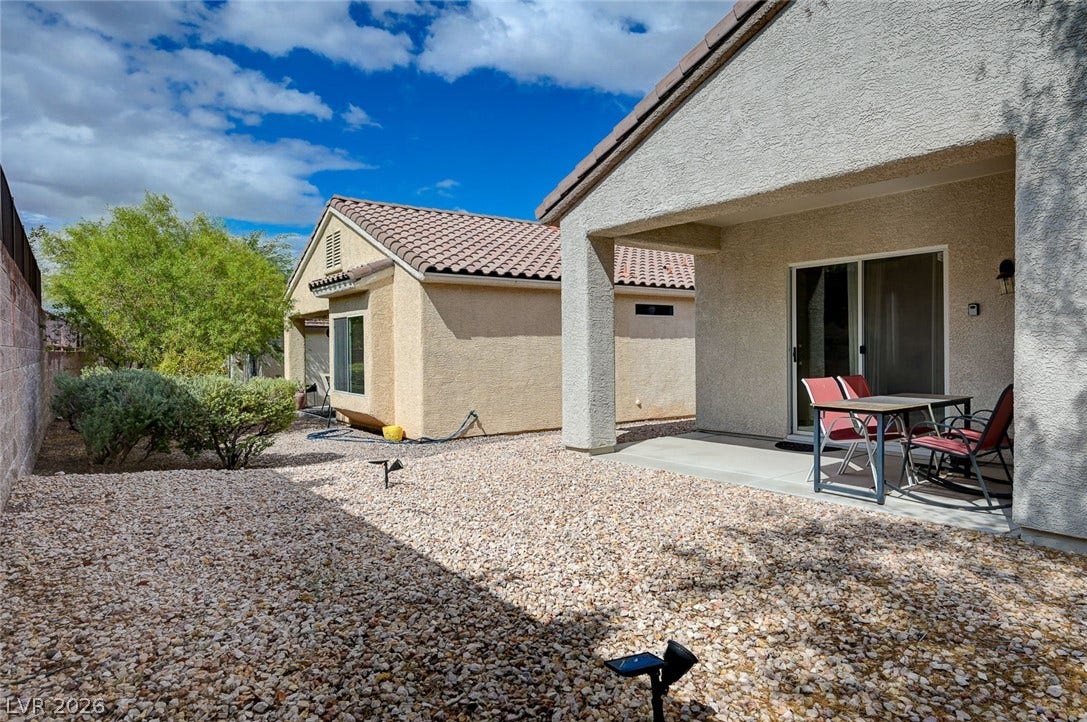 2851 Sapphire Desert Drive, Henderson, NV 89052 A covered back patio opens to a low-maintenance gravel yard under sunny skies.