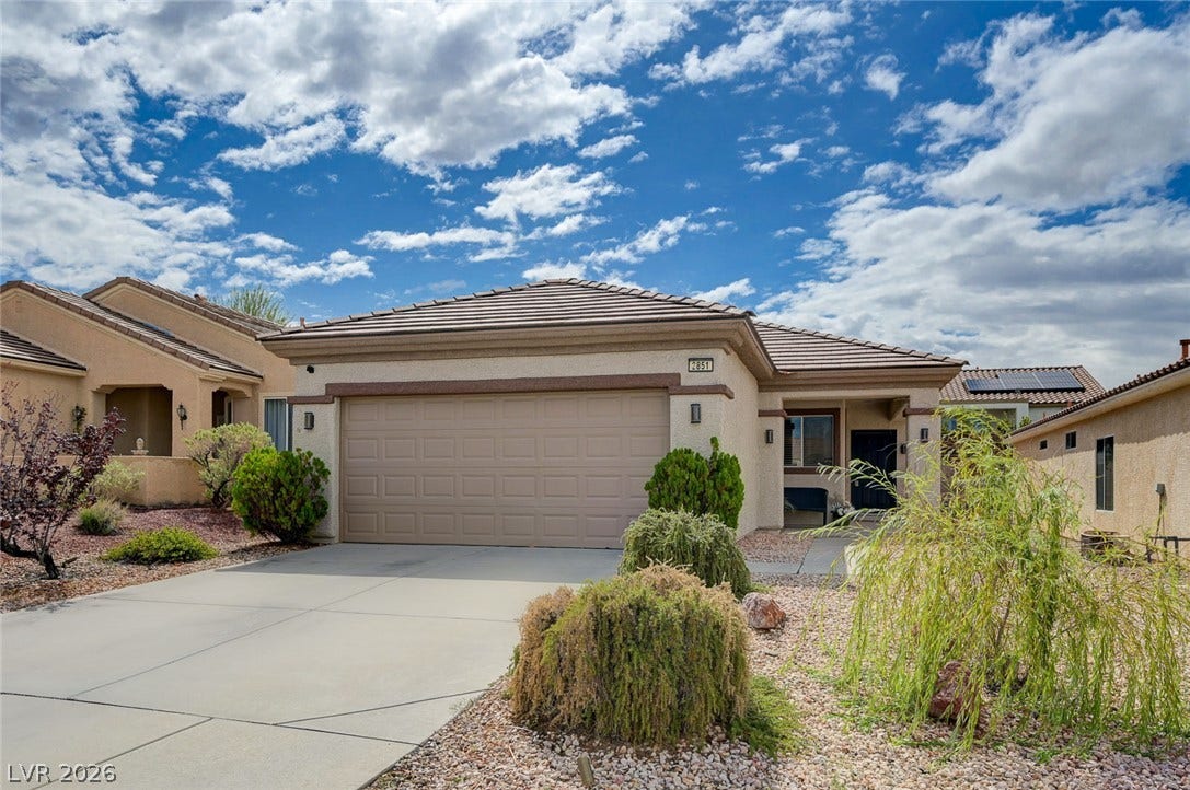 2851 Sapphire Desert Drive, Henderson, NV 89052 Desert landscaping and a wide concrete driveway frame this single-story home under a blue sky.