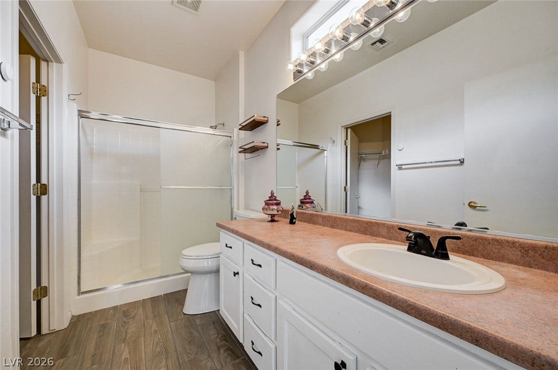 2851 Sapphire Desert Drive, Henderson, NV 89052 A spacious vanity counter pairs with wood-look flooring in this functional secondary bathroom.