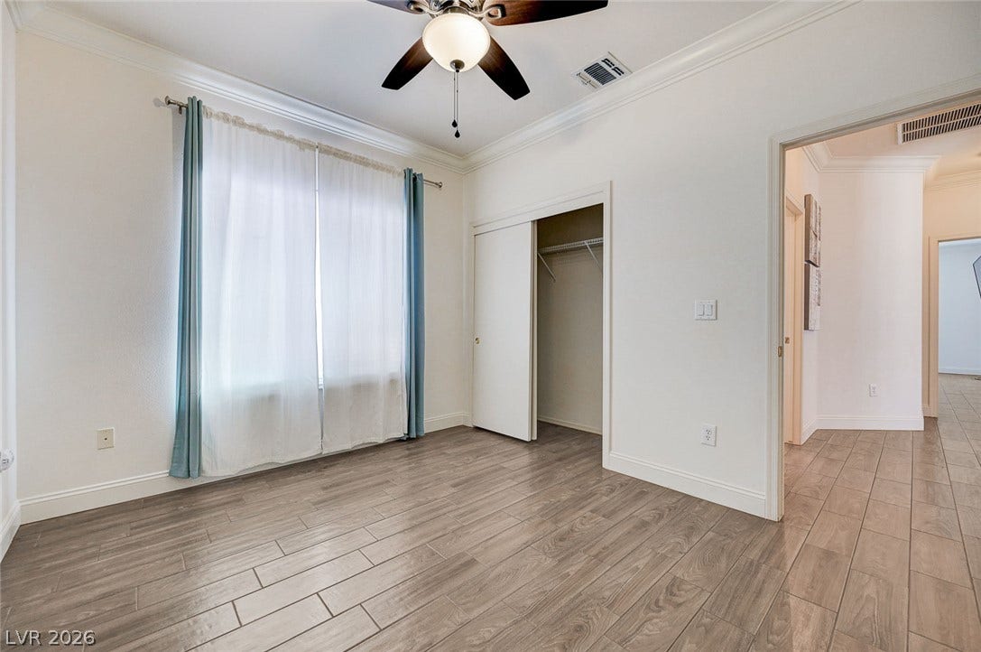 2851 Sapphire Desert Drive, Henderson, NV 89052 Elegant crown molding complements the sleek wood-look plank flooring in this versatile bedroom.