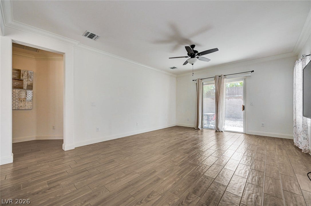2851 Sapphire Desert Drive, Henderson, NV 89052 Wood-look tile flooring and elegant crown molding frame a spacious living area opening outdoors.