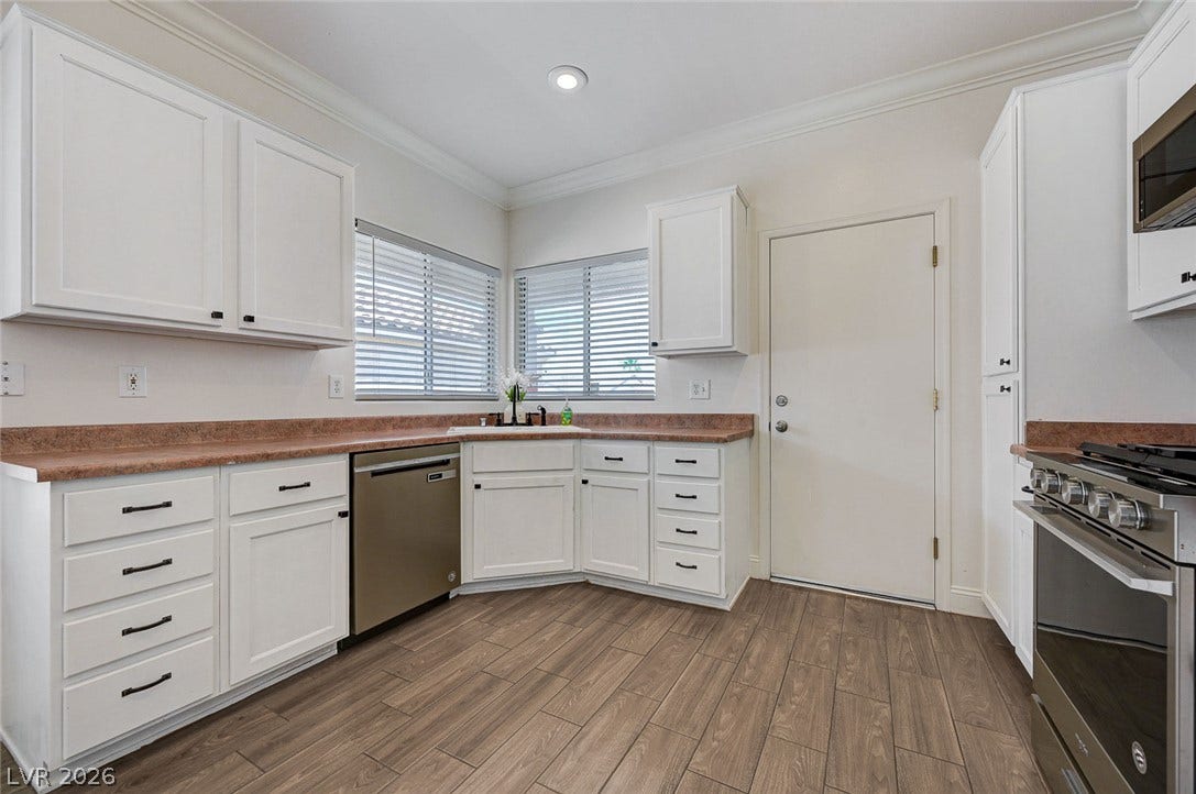 2851 Sapphire Desert Drive, Henderson, NV 89052 Gleaming wood-look tile floors and classic crown molding anchor this modern, light-filled kitchen space.