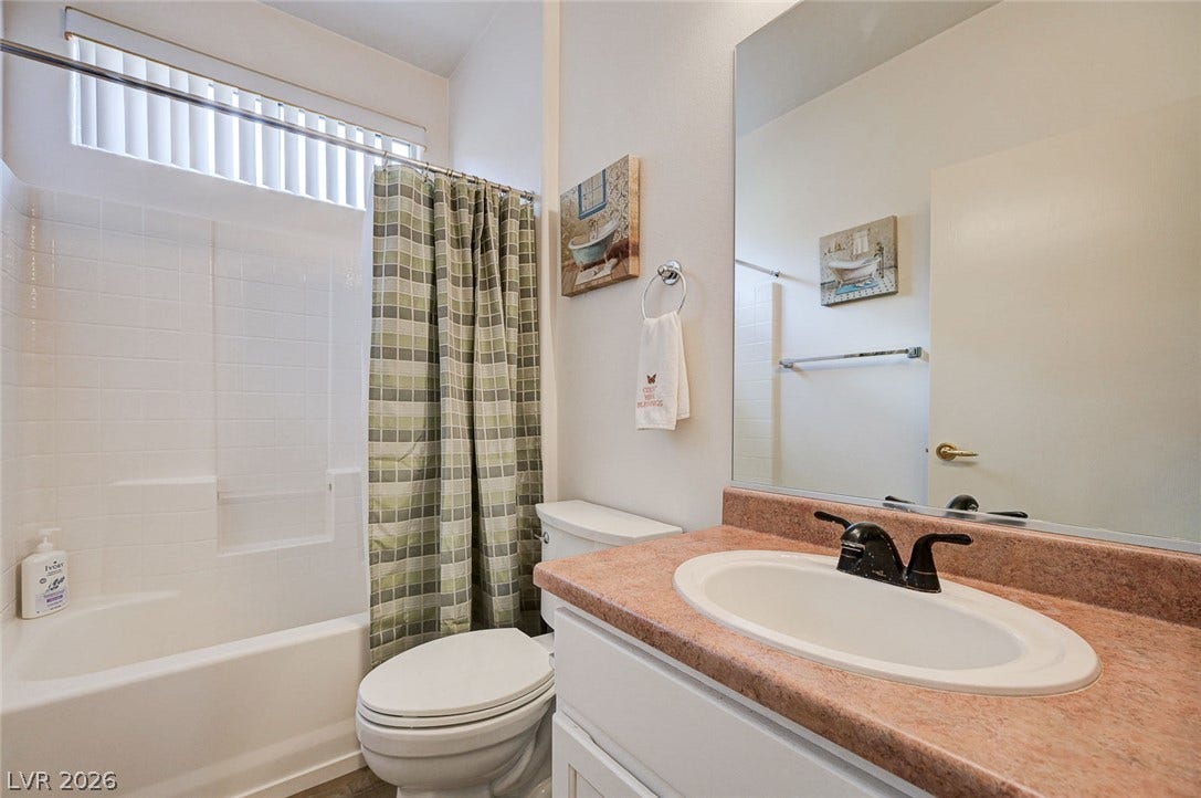 2851 Sapphire Desert Drive, Henderson, NV 89052 Functional bathroom layout features a tub and shower combination next to a classic vanity.