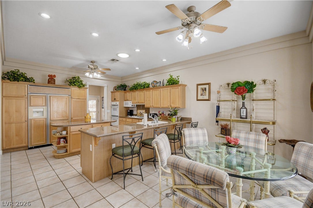 2000 Alexa Breanne Court, Las Vegas, NV 89117 Crown molding and tiled floors define this spacious eat-in kitchen with custom cabinetry.
