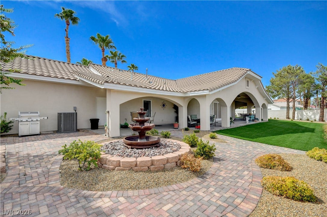 2000 Alexa Breanne Court, Las Vegas, NV 89117 Elegant arched walkways overlook a manicured lawn and a brick-paved patio with a central fountain.