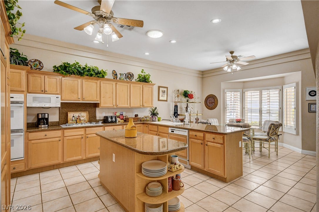 2000 Alexa Breanne Court, Las Vegas, NV 89117 Warm wood cabinetry paired with neutral tile floors grounds this spacious culinary space.