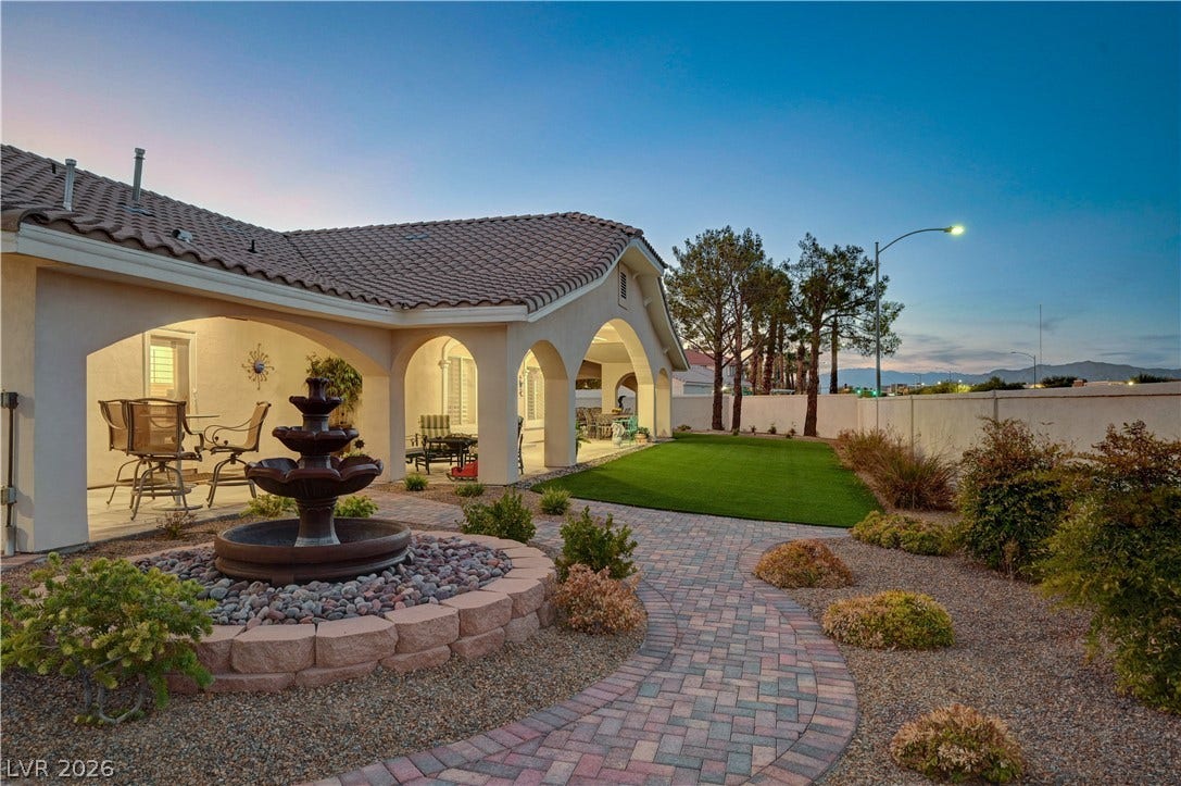 2000 Alexa Breanne Court, Las Vegas, NV 89117 An arched covered patio overlooks a beautifully landscaped yard featuring a curved paver path.