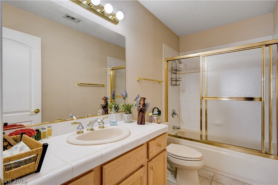 2000 Alexa Breanne Court, Las Vegas, NV 89117 Warm wood cabinetry and tile countertops ground this classic bathroom design.