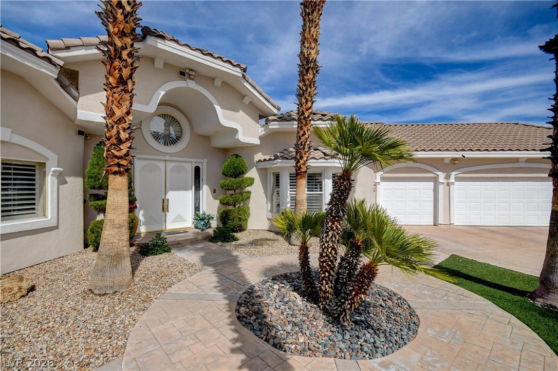 2000 Alexa Breanne Court, Las Vegas, NV 89117 Palm trees frame the arched entryway and multi-car garage of this single-story desert home.
