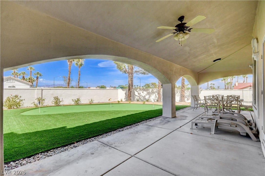2000 Alexa Breanne Court, Las Vegas, NV 89117 An arched patio overlooks a backyard putting green under desert skies.