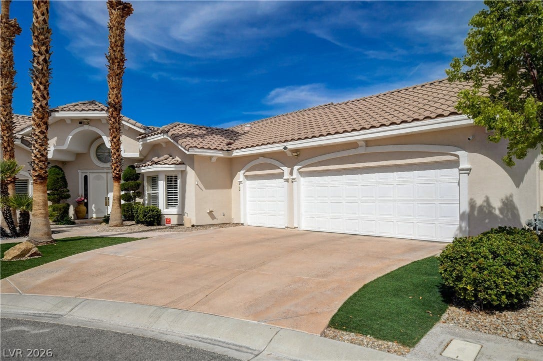 2000 Alexa Breanne Court, Las Vegas, NV 89117 A spacious driveway leads to three garage bays under a classic tile roof.