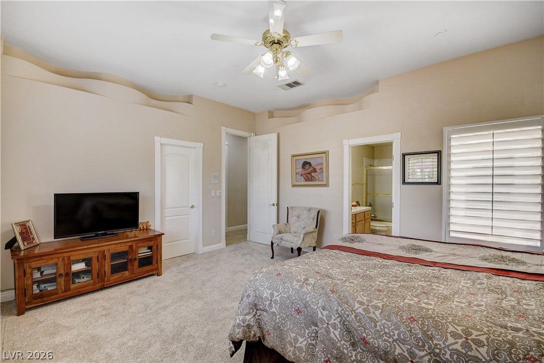 2000 Alexa Breanne Court, Las Vegas, NV 89117 A spacious bedroom offers plush carpeting and unique architectural wall ledges below the high ceiling.