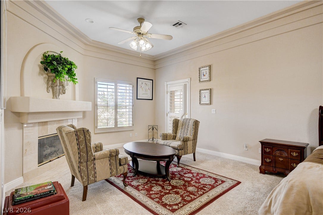 2000 Alexa Breanne Court, Las Vegas, NV 89117 An elegant fireplace anchors this spacious retreat completed by crown molding and plush carpet.