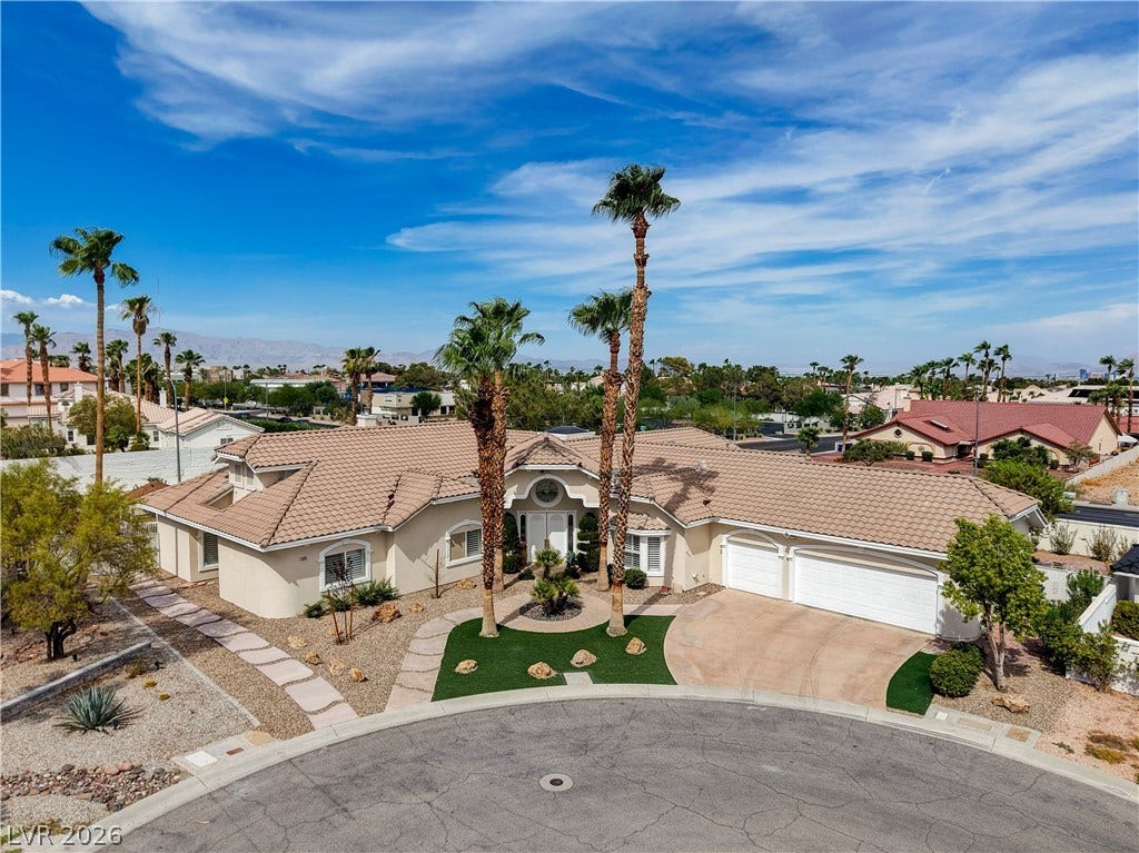 2000 Alexa Breanne Court, Las Vegas, NV 89117 Palm trees frame the curved driveway and tile roof of this desert-style home.