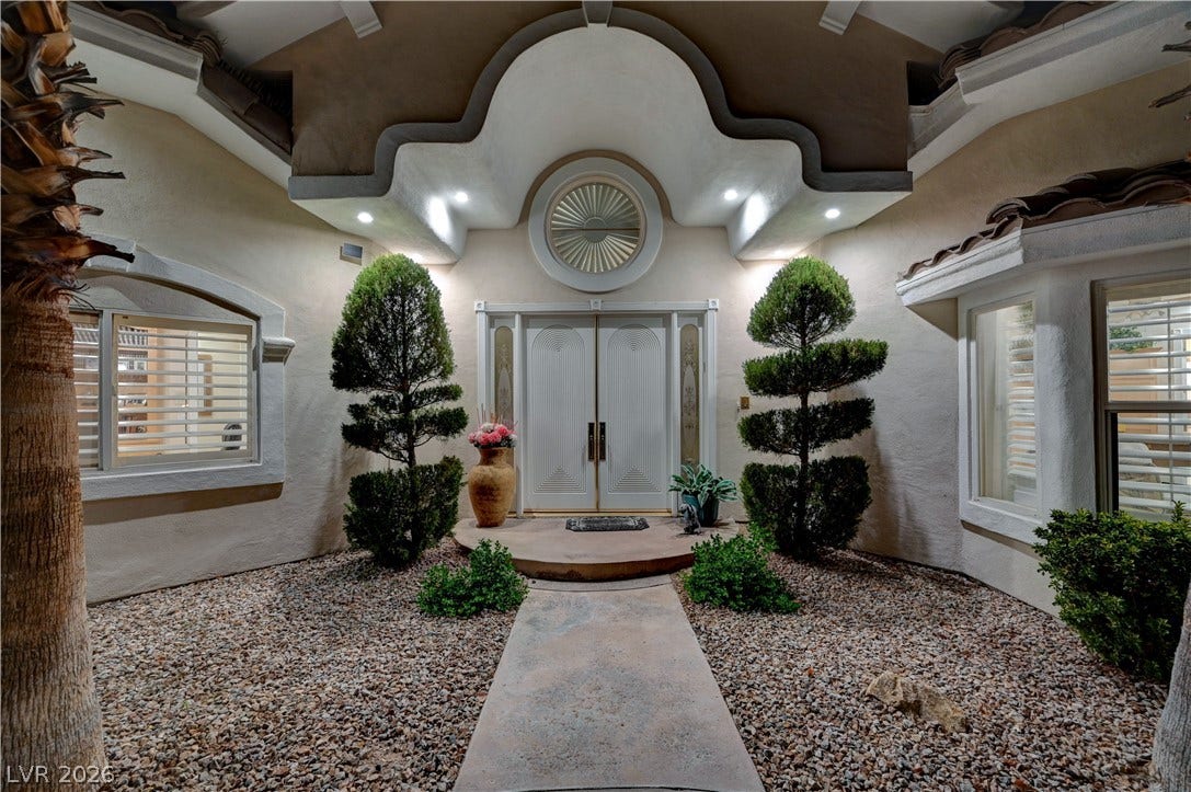 2000 Alexa Breanne Court, Las Vegas, NV 89117 Ornate architectural molding frames the double door entry welcoming visitors along a paved concrete walkway.