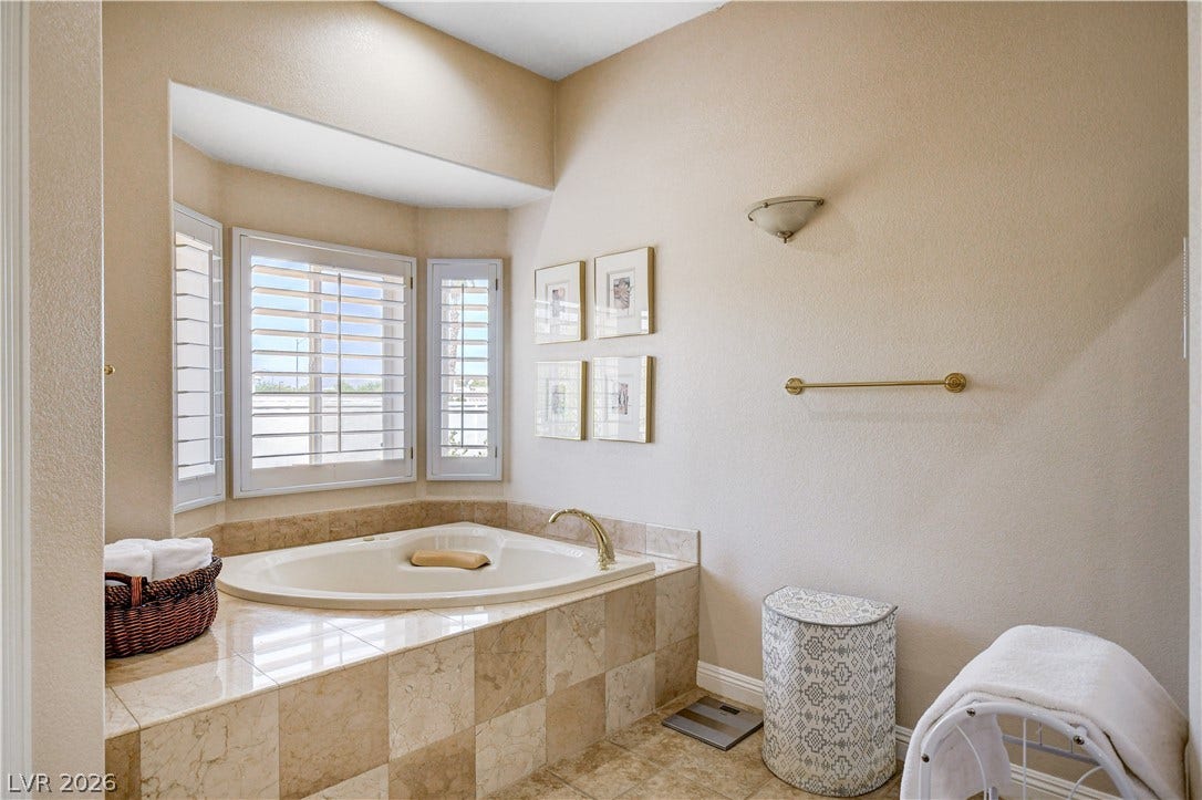 2000 Alexa Breanne Court, Las Vegas, NV 89117 An inviting corner soaking tub is framed by elegant tile surround and classic plantation shutters.