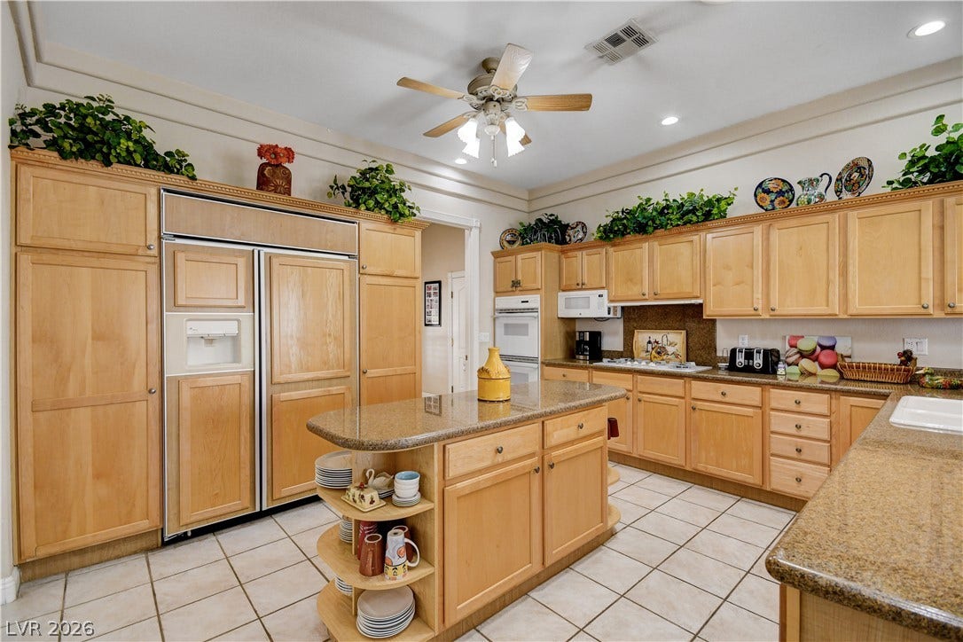 2000 Alexa Breanne Court, Las Vegas, NV 89117 Ample wooden cabinetry and stone countertops anchor this classic kitchen layout.
