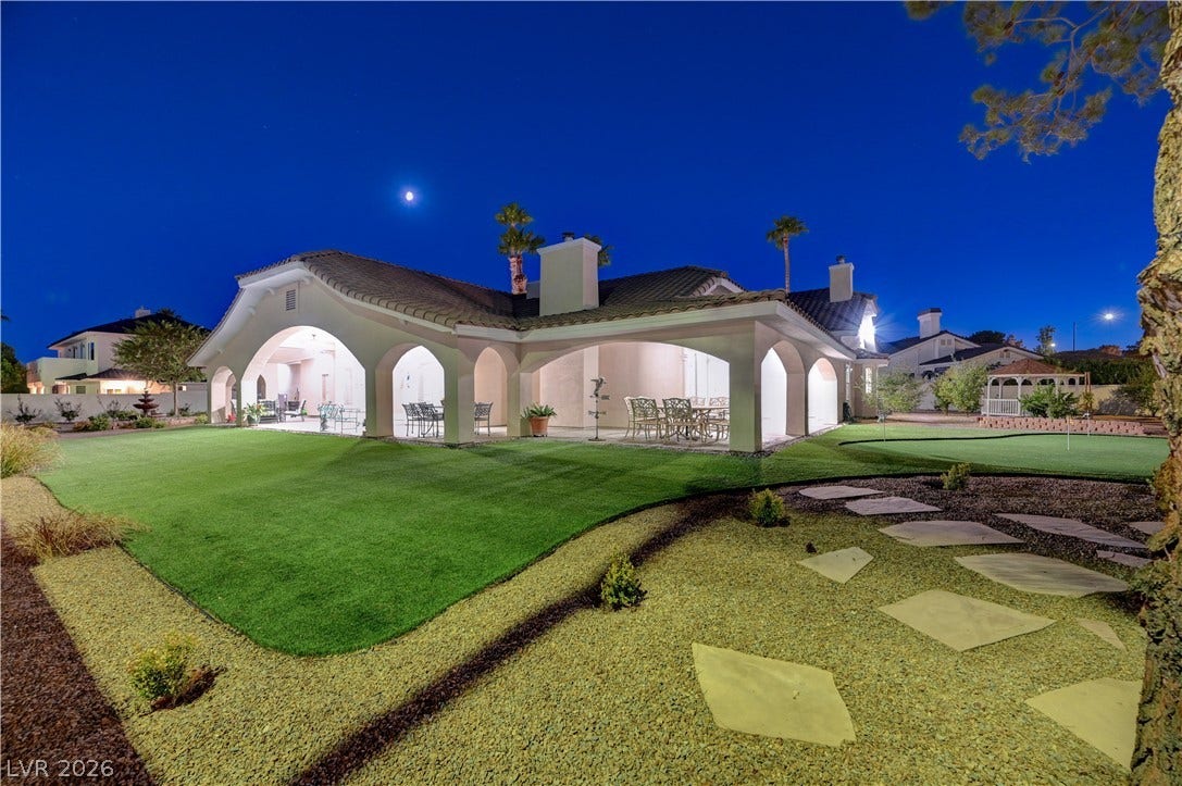 2000 Alexa Breanne Court, Las Vegas, NV 89117 A spacious covered patio overlooks a manicured green lawn framed by elegant arches.