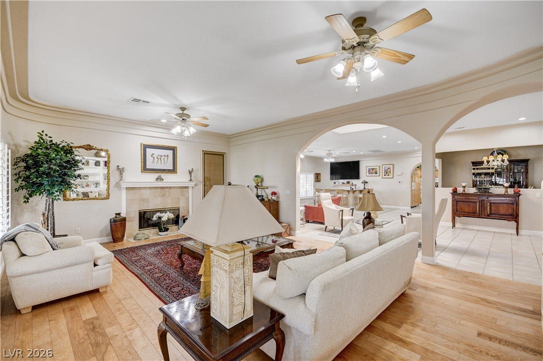2000 Alexa Breanne Court, Las Vegas, NV 89117 Hardwood floors and an arched entryway define this light-filled living space with a classic fireplace.