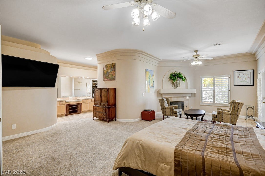 2000 Alexa Breanne Court, Las Vegas, NV 89117 Crown molding and a cozy fireplace enhance this spacious bedroom suite.
