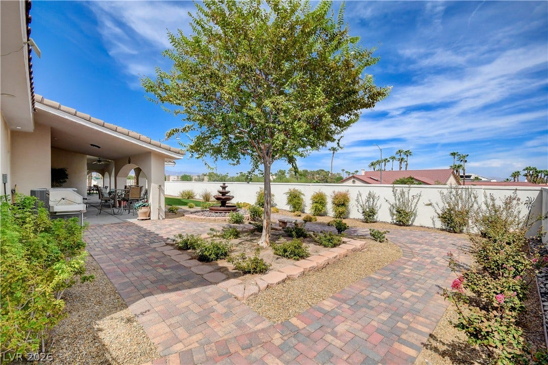 2000 Alexa Breanne Court, Las Vegas, NV 89117 A beautifully paved walkway winds through the landscaped backyard under clear blue skies.