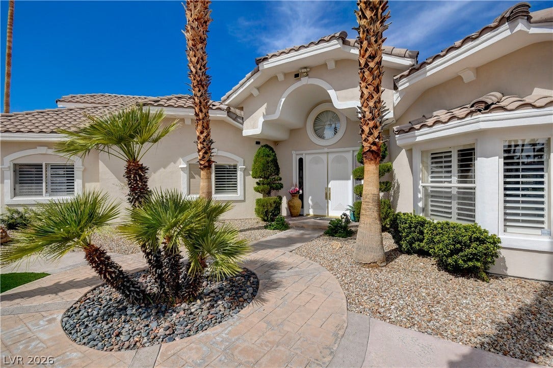 2000 Alexa Breanne Court, Las Vegas, NV 89117 A curved stone pathway leads to a grand double-door entrance framed by classic stucco archways.