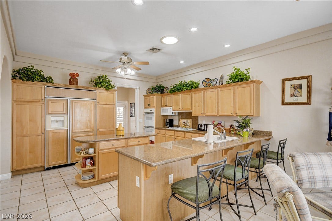 2000 Alexa Breanne Court, Las Vegas, NV 89117 Gleaming stone countertops and classic wood cabinetry define this functional kitchen space.