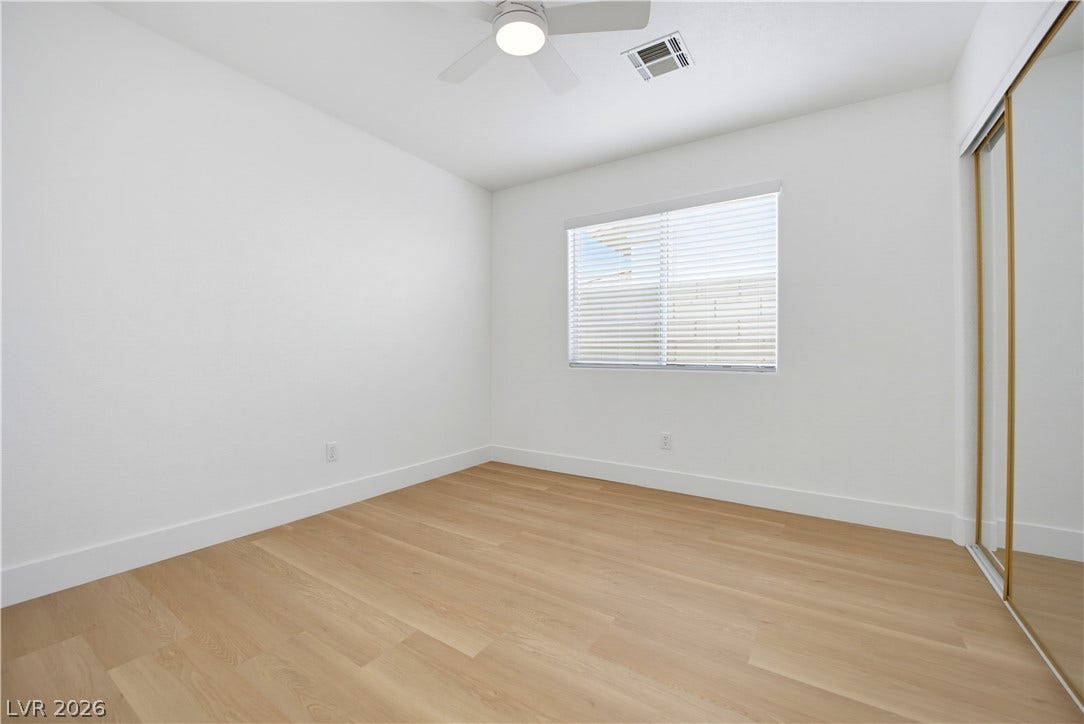 4722 Casa Bonita Drive, North Las Vegas, NV 89032 Smooth wood-style flooring and mirrored sliding closet doors frame this versatile secondary bedroom.