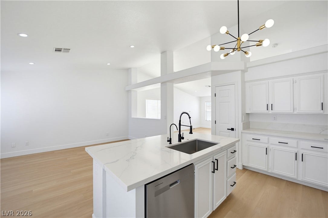 4722 Casa Bonita Drive, North Las Vegas, NV 89032 Gleaming stone countertops and a modern kitchen island complement the light-toned wood floors.