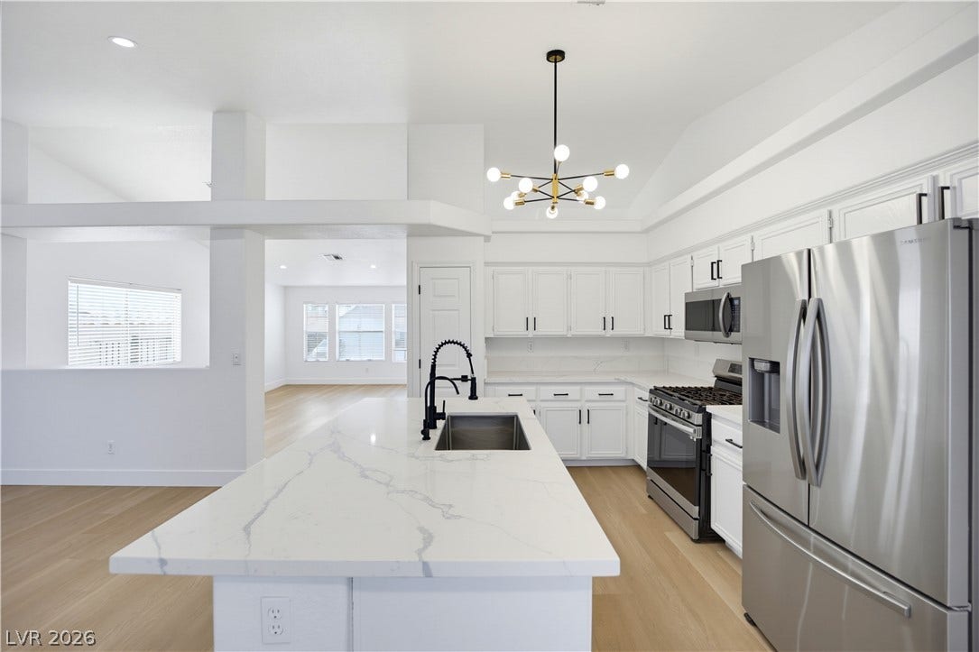 4722 Casa Bonita Drive, North Las Vegas, NV 89032 Crisp white cabinetry paired with stone countertops defines this open-concept culinary space.