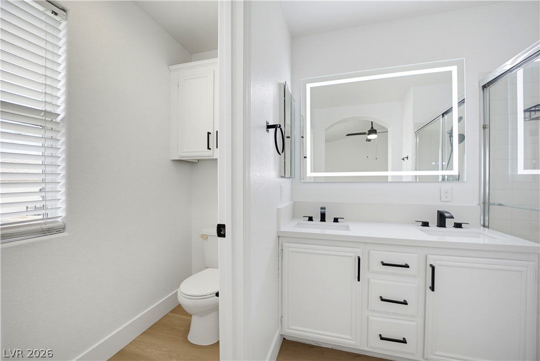 4722 Casa Bonita Drive, North Las Vegas, NV 89032 A contemporary double vanity pairs with clean lines and warm wood-style flooring.