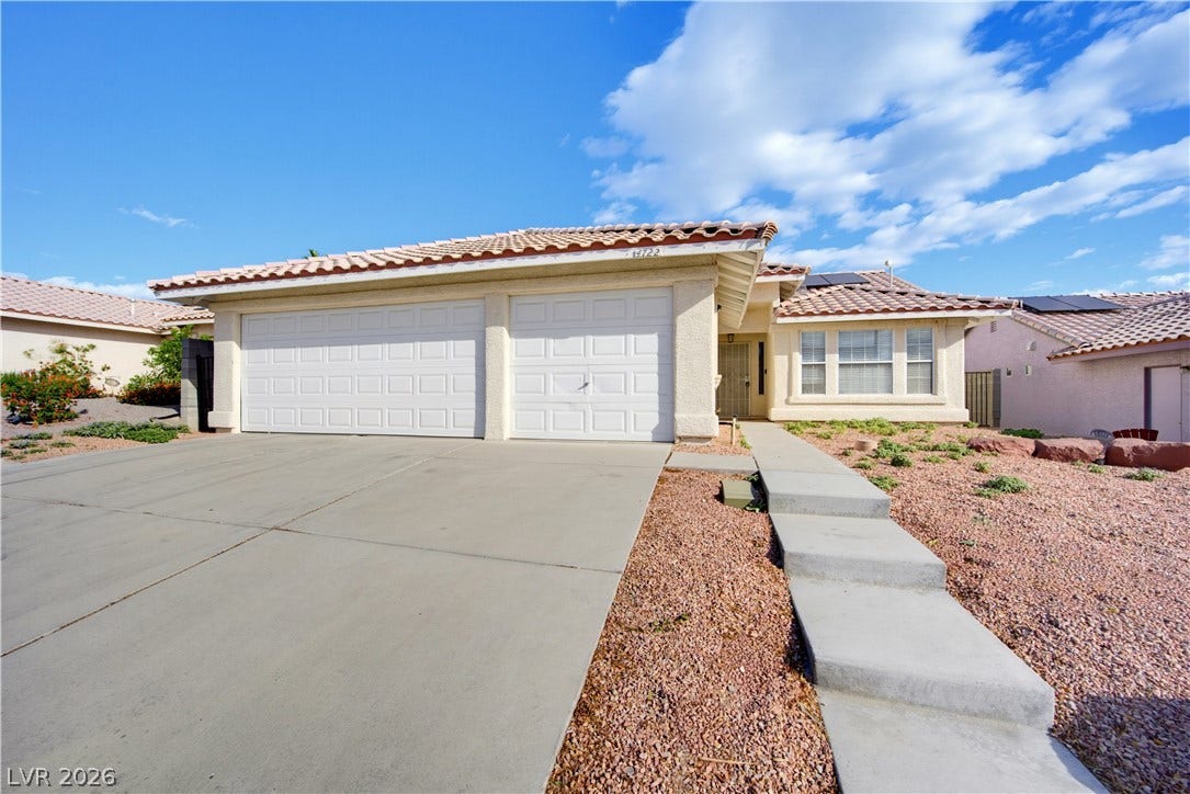 4722 Casa Bonita Drive, North Las Vegas, NV 89032 A spacious concrete driveway leads to the three-car garage of this tile-roofed desert home.