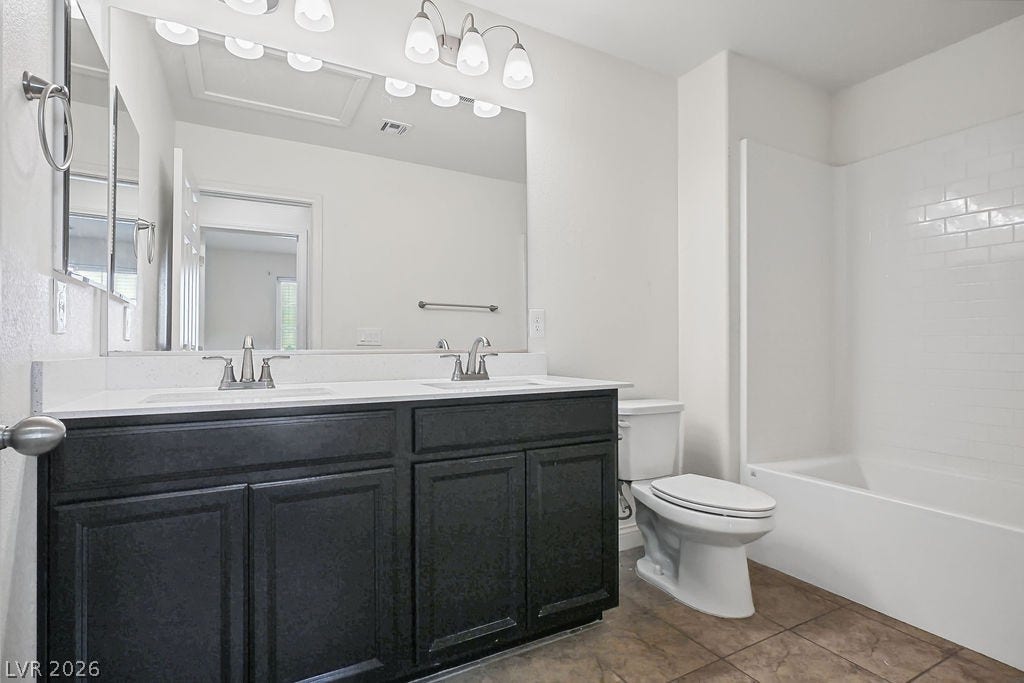 Clean lines and a spacious dual vanity define this modern bathroom space.